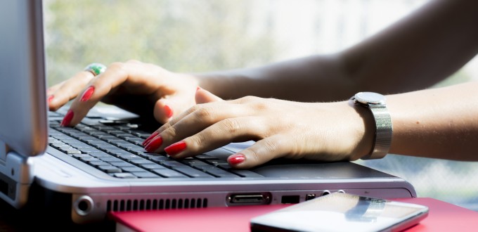 Hands of a businesswoman typing on a computer keyboard